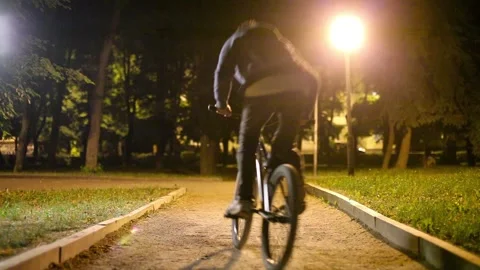 Young guy doing a sliding trick on a bicycle and falls from it Stock Footage 168414945