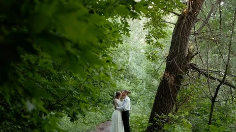 Young guy with dreadlocks and a hipster girl kissing in the park. Wedding Stock Footage 123589539