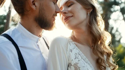 A young guy with dreadlocks kisses a cute girl in the forest. Hipster wedding Stock Footage 123727887
