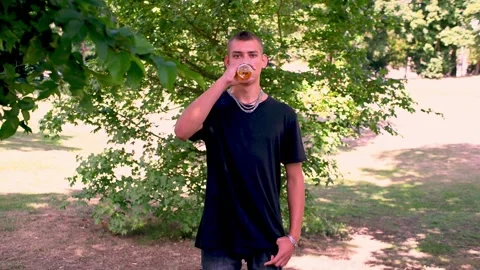 Young guy drinking beer on the street Stock Footage 228665455
