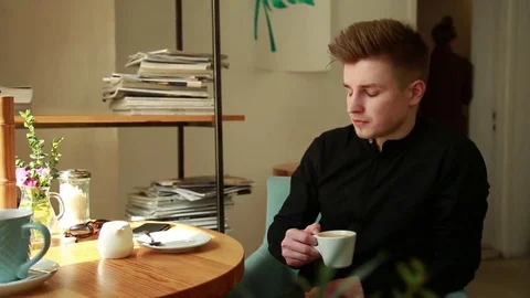 Young Guy drinks Coffee sitting in the Office Stock Footage 80601988