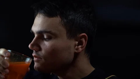 The young guy drinks freshly squeezed carrot juice Stock Footage 120253210