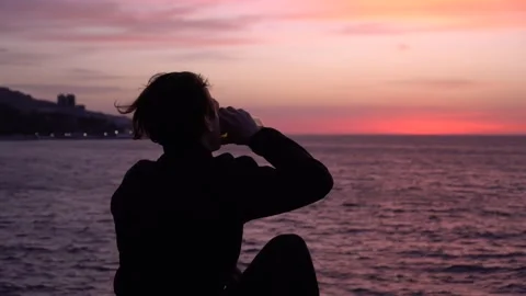 A young guy drinks water from a reusable bottle. Travel, nature, sea, beach Video stock 151036427