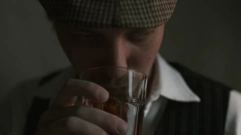 Young guy drinks whiskey, dressed in a retro style Stock Footage 149871287