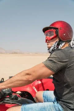 Young guy during desert excursion by quad - Man in helmet and adventure cloth Stock Photos