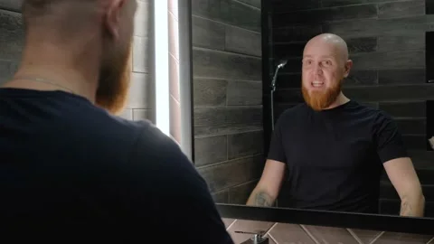 The young guy is energized by talking to his reflection in the mirror. Stock-Footage 138998338