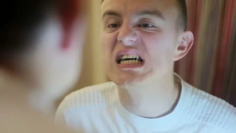 Young guy examines his teeth in the mirror Stock-Footage 122736124