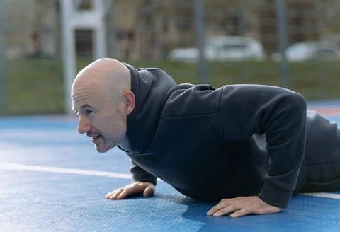 A young guy is exercising outdoors. A guy is doing a plank or push-up exercis Foto stock