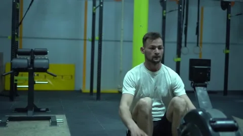 Young guy exercising on row machine in crossfit gym. Stock Footage 131329801