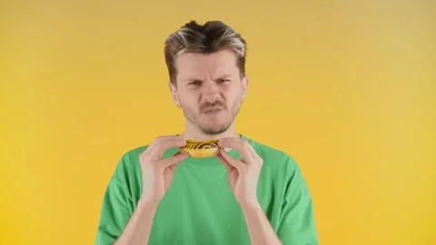 The young guy first sniffs and then bites off the cake and shakes his head Video stock 241781323