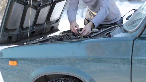 A young guy fixes a breakdown of his car Stock Footage 85169822