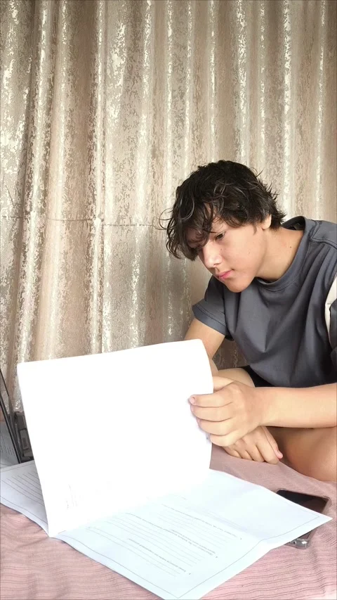 A young guy is flipping through the pages of a document 動画素材 311654001
