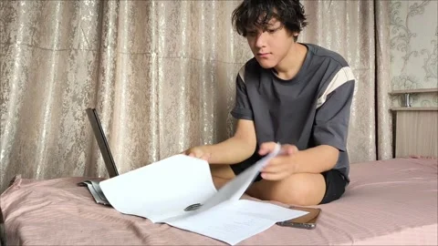 A young guy is flipping through the pages of a document Stock Footage 311654008