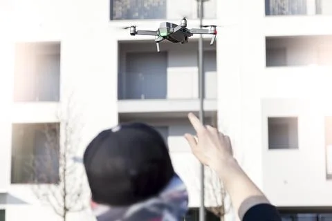 Young guy is flying a drone with remote control outdoor Stock Photos
