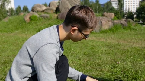 A young guy geek in glasses is studying the drone, turns it over. Checks the mou Stock Footage 84662266