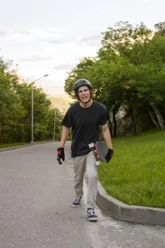 The young guy gets angry after the longboard trick does not work out Stock Photos