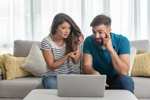 Young guy gets bored is girlfriend shows online laptop hairdresser ruined hair Stock Photos