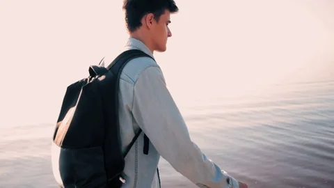 Young guy gets a message on the smartphone on the beach 스톡 동영상 79036512