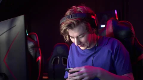 A young guy gets a phone call during an online video game, he takes off his Stock Footage 152798228