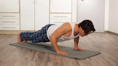 A young guy with glasses was doing push-ups at home on a mat, not in sportswear Vidéo 259489591