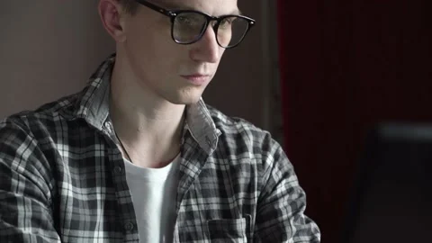 A young guy in glasses is working on a black laptop at home. panorama. Stock Footage 236690000