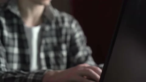 A young guy in glasses is working on a black laptop at home. panorama. Stock Footage 237017649