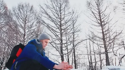 A young guy with a good physique sits by the fire Stock Footage 76598760