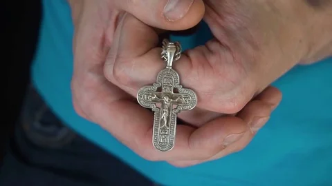 The young guy hands Christian cross and praying to God in heaven. Daily Видео 77078917