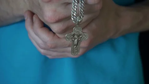 The young guy hands Christian cross and praying to God in heaven. Daily 스톡 동영상 77079371