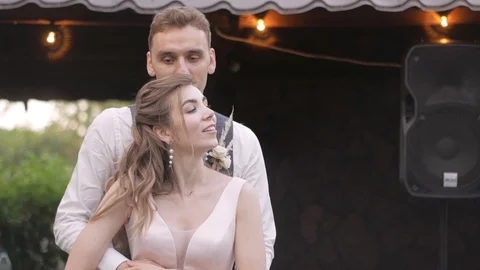 A young guy has fun dancing with a girl and hugs her from behind Stock Footage 127933244