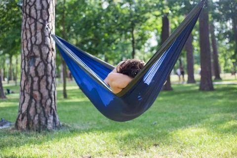 Young guy has a rest in summer in a hammock Stock Photos