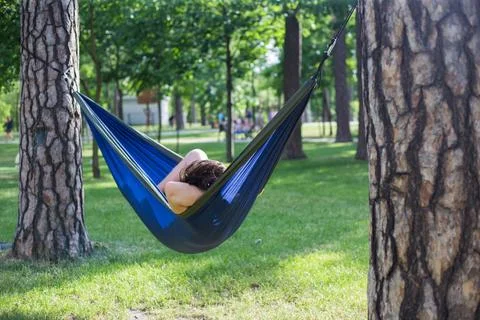Young guy has a rest in summer in a hammock Stock Photos