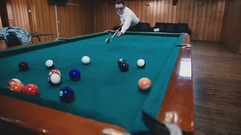Young guy hits the balls in the billiards and rejoices Stock Footage 81476656