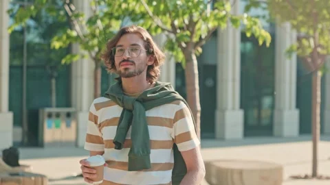 Young guy holding eco cup and drinking coffee. Caucasian man smiling at Video stock 278910904