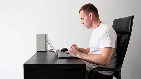 A young guy at home working at a computer in quarantine Stock Footage 127409436