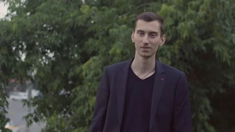 A young guy in a jacket holds a glass and dances Stockbeeldmateriaal 155945888