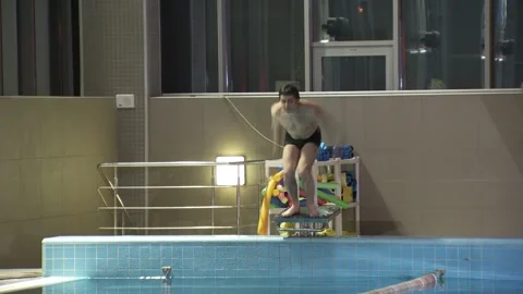 Young guy is jumping into the swimming pool. Vídeos de archivo 134729420