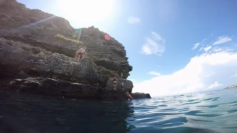 Young guy jumping into the water while doing flips Video stock 102019036