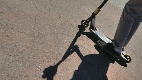 A young guy jumps and does tricks on a scooter in a skatepark Video stock 94142630