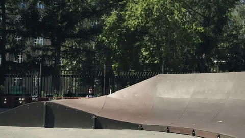 A young guy jumps and does tricks on a scooter in a skatepark Video stock 94142835