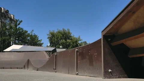 A young guy jumps and does tricks on a scooter in a skatepark Stock-Footage 94142869