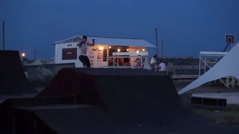 Young guy jumps on roller skates in skatepark Stock Footage 102785769