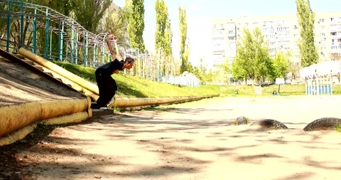 A young guy jumps from the stairs onto a small tire in parkour style Stock Footage 265051264