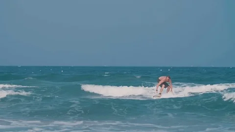 Young guy learns to surf Stock Footage 73794174