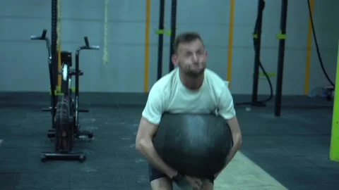 Young guy lifting weight sandbag training in gym. Crossfit training Stock Footage 131329874