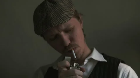 Young guy lights a cigarette, dressed in a retro style Stock Footage 149872206