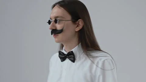 Young guy with long hair with a false moustache Stock Footage 287915699