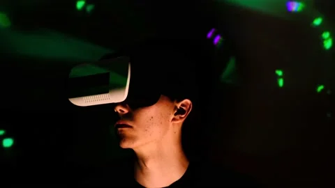 Young guy looking around surprised. Man watches and using VR-helmet virtual real Stock-Footage 130176393