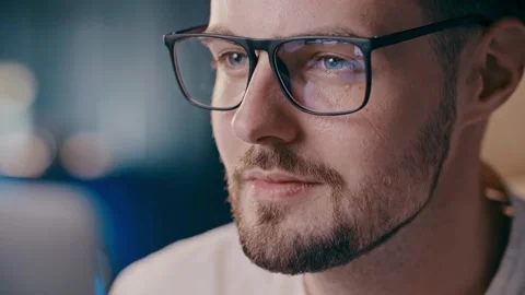 Young guy looking at screen with glasses reflection. Positive student man Stock Footage 256803029