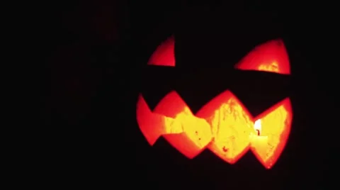 Young guy looks on burning candle inside of carved pumpkin jack o lantern then Stock Footage 68175848